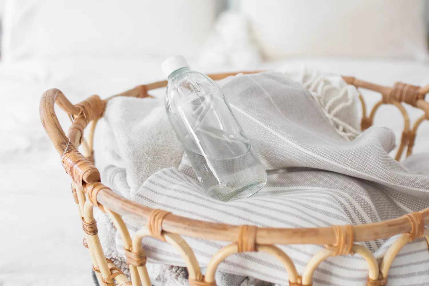 bottle of white vinegar atop a laundry pile